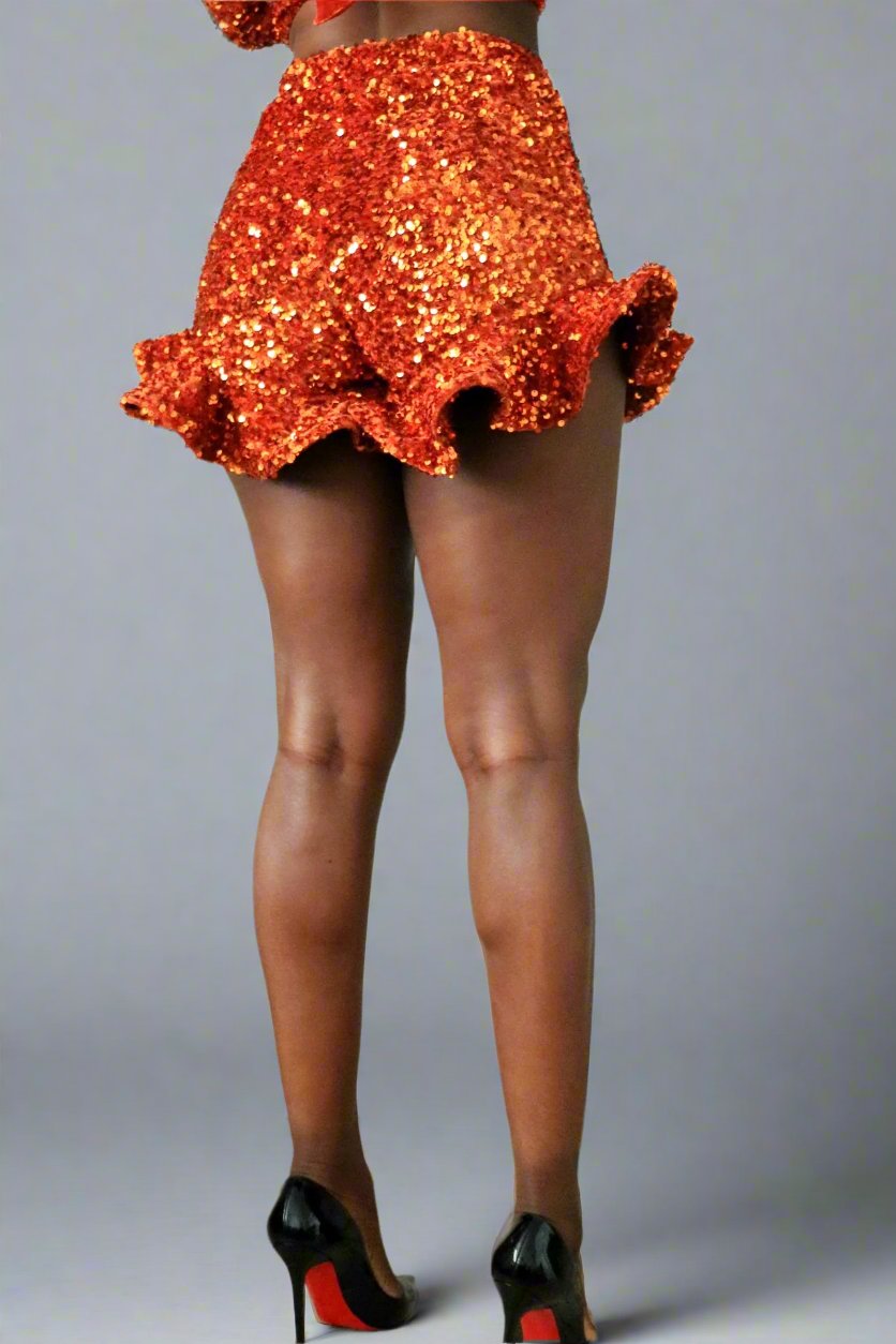 Back view of model wearing high waist burnt orange sequin ruffle shorts 