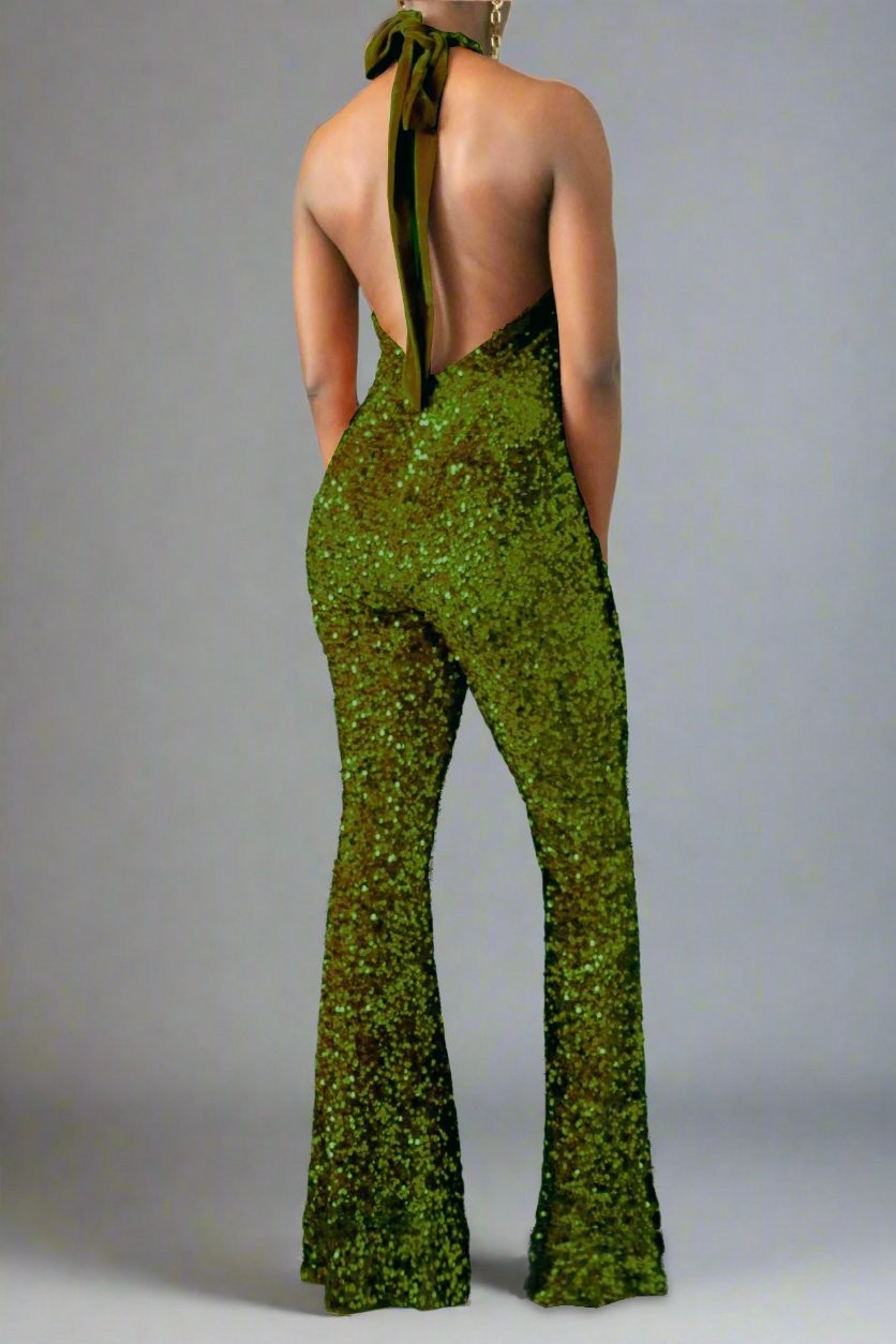 The model is wearing the back view of an olive green sequin halter backless flare leg jumpsuit. 