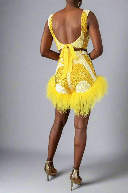 back front view of a model wearing a yellow and white sequin swirl high waist feather shorts. Square neck matching top  