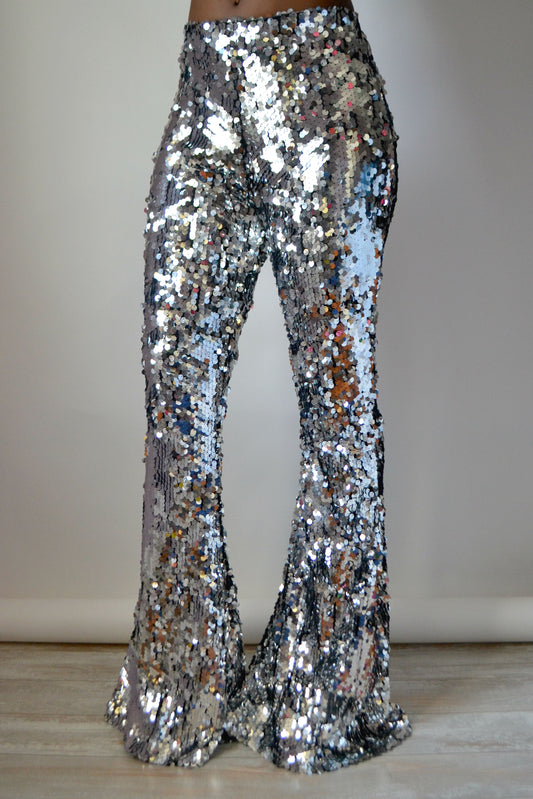 Silver sequin bell-bottom pants on a plain background