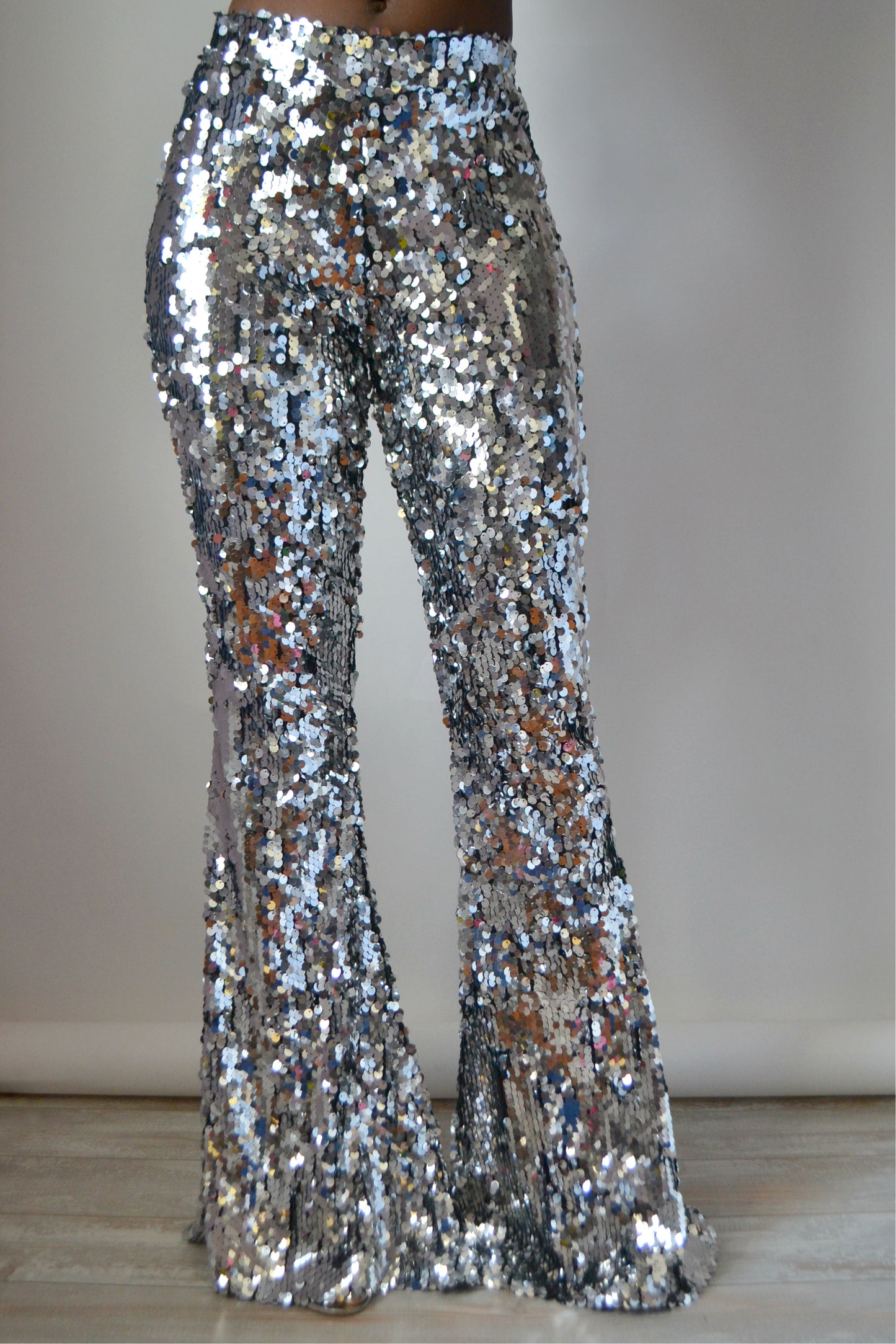 Full frontal view of silver sequin pants on a plain background