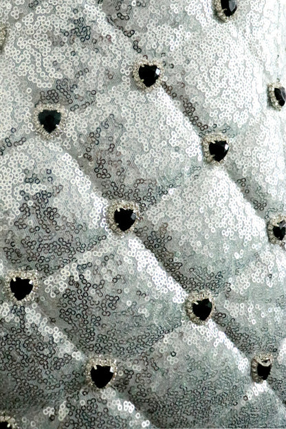close up detail of sequin quilt pattern with black heart rhinestone detail on pattern