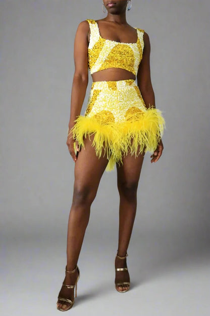 Full front view of a model wearing a yellow and white sequin swirl high waist feather shorts. Square neck matching top  