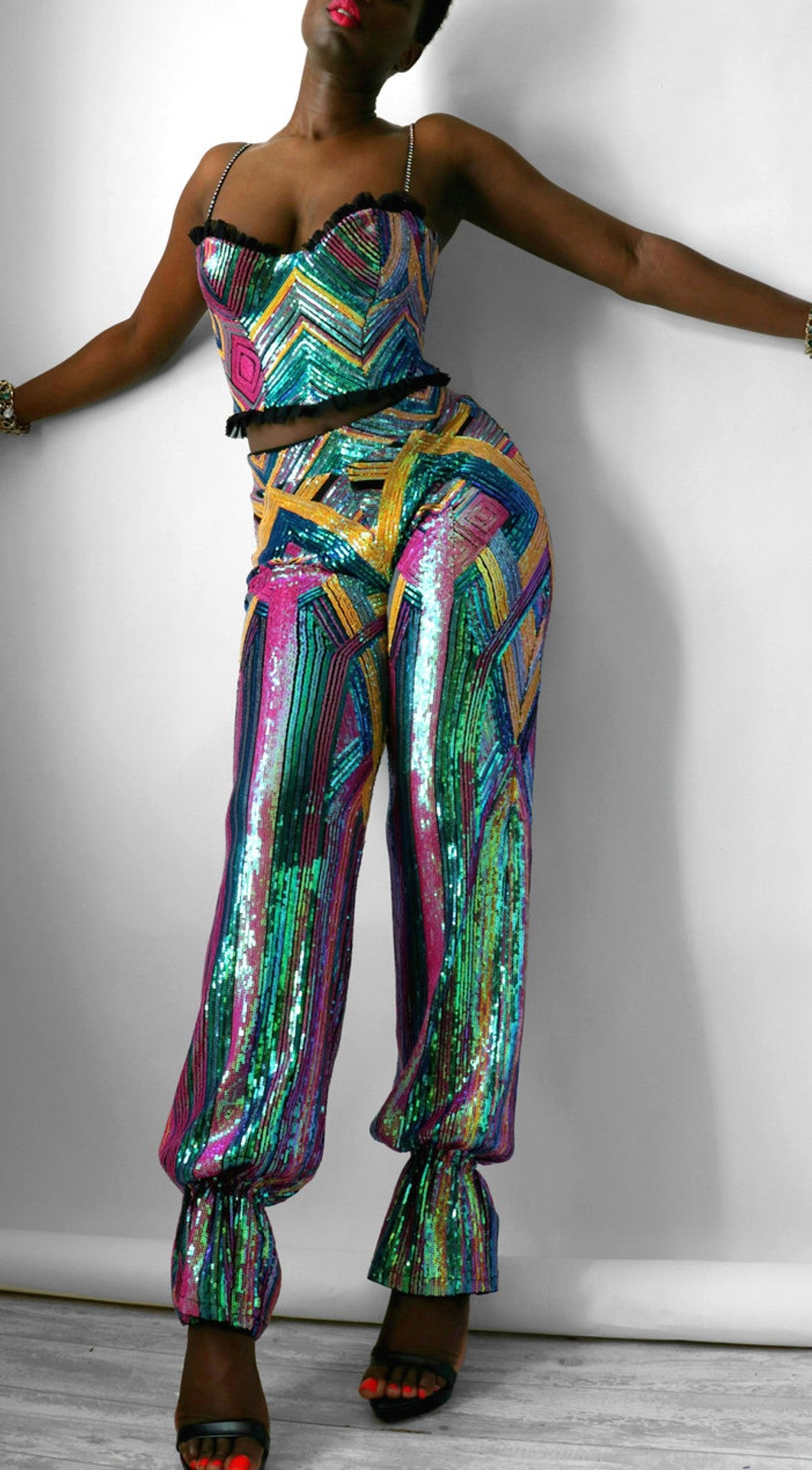 Model wears a colorful geometric sequin harem pants