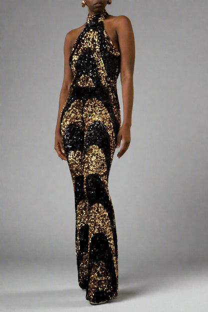 Front side view of a model wearing a black & gold sequin swirl pattern halter jumpsuit