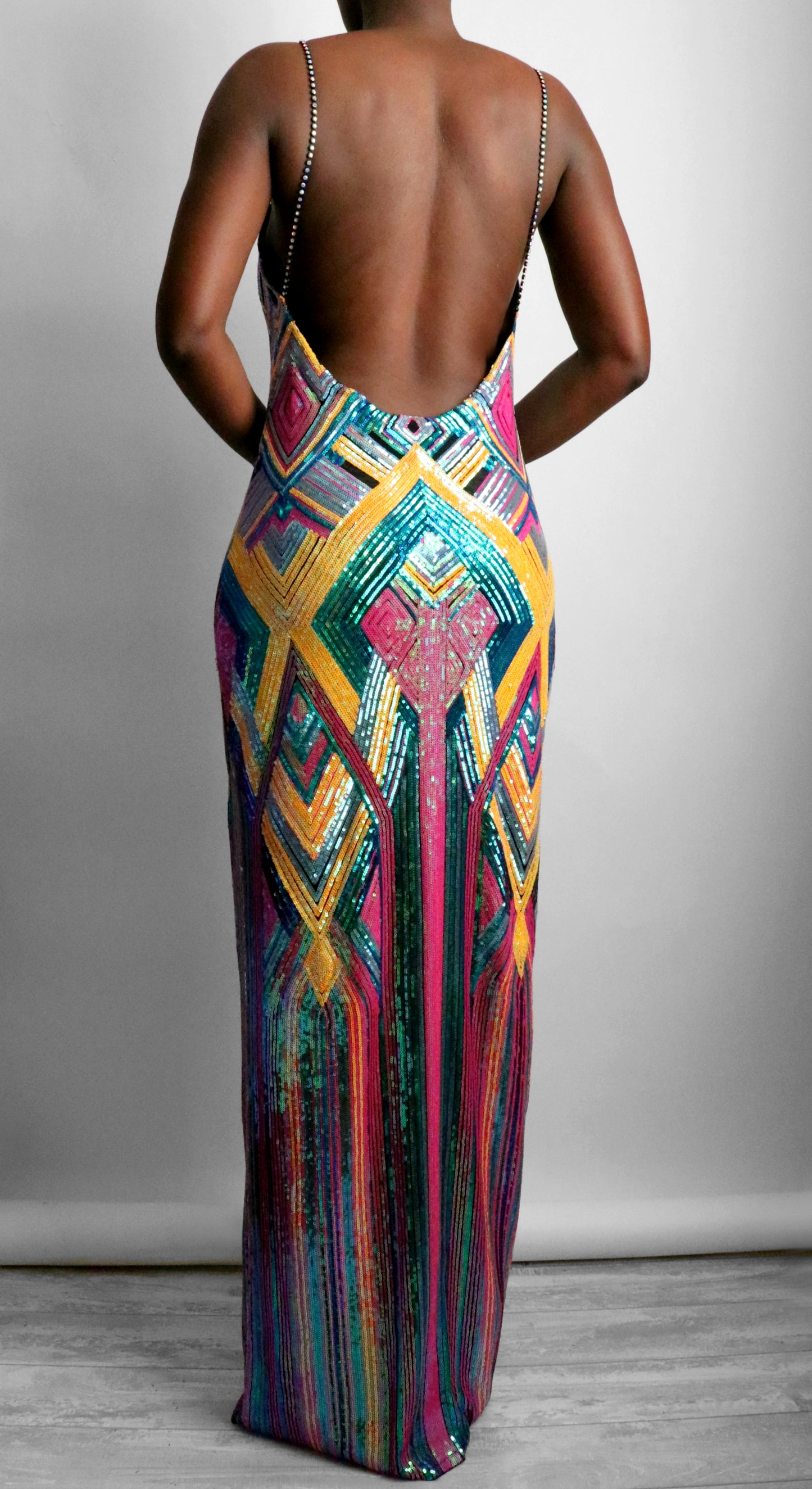Multicolored patterned sequin dress with open back on a plain background